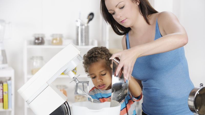 Une mère utilise un robot de cuisine avec son fils.
